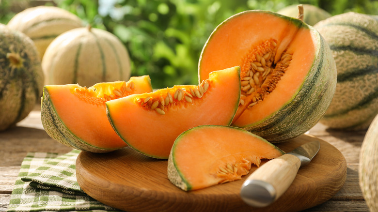 cantaloupe sliced into wedges on a wooden board