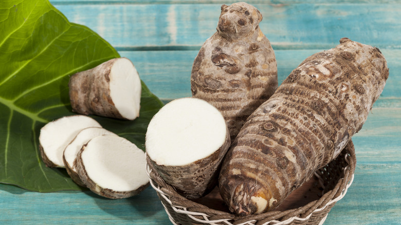 whole and sliced taro root in a basket