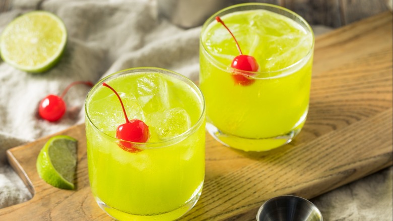 Two Midori Sour cocktails with cherries