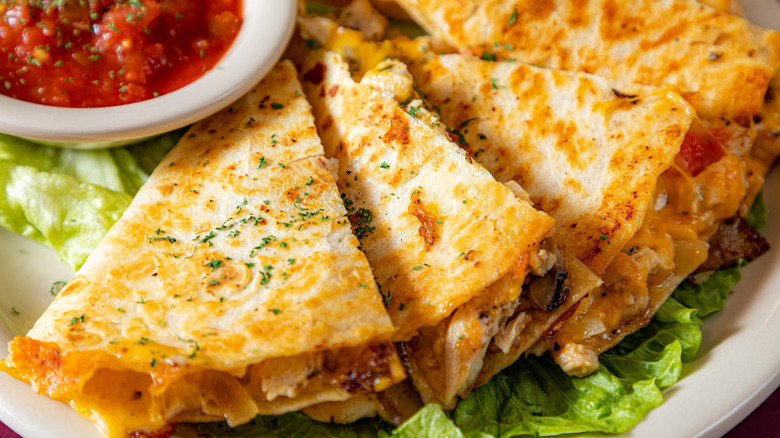 Closeup of a cheese quesadilla with a side of salsa