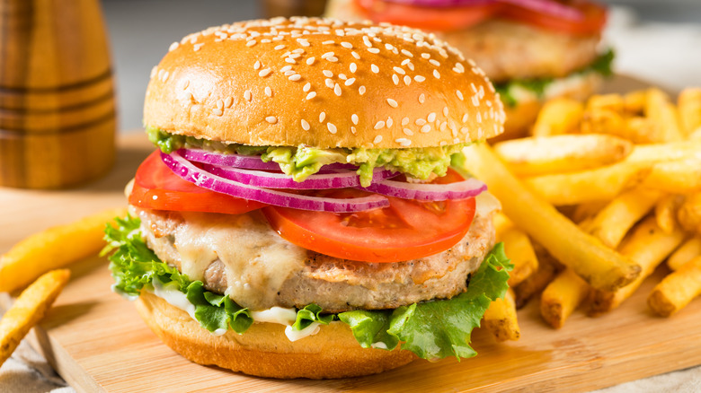 thick, homemade turkey burger on a bun with lettuce, tomatoes, and fixings