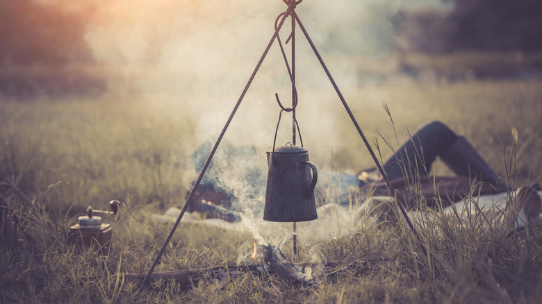 Cowboy brewing coffee over an open fire