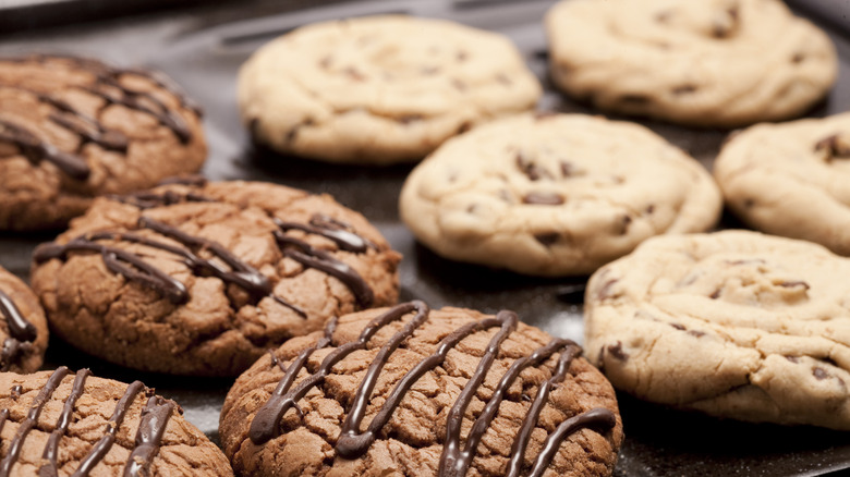 Rows of chocolate cookies with chocolate drizzle next to chocolate chip cookies