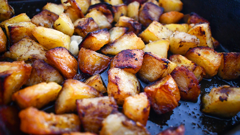 Close up of crispy, roasted potato chunks in a baking pan