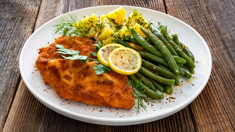 fried breaded pork chop with green beans and potatoes