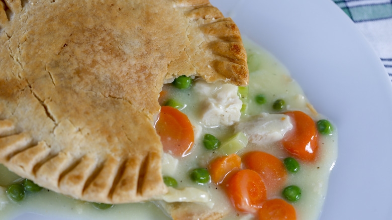 chicken pot pie with filling on a white plate