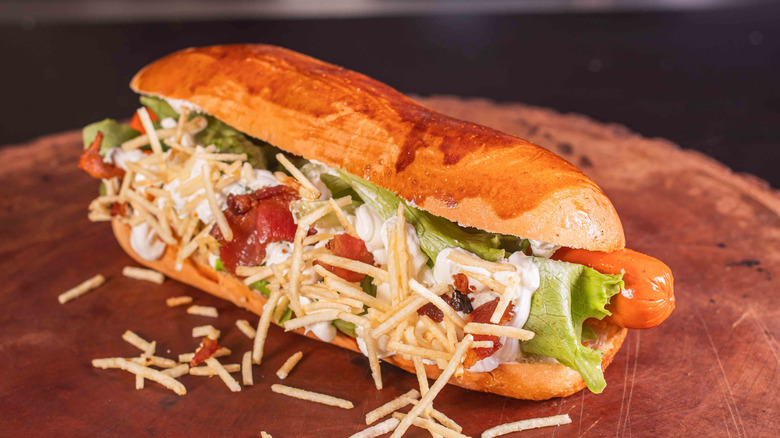 A Brazilian style hot dog on a chopping board