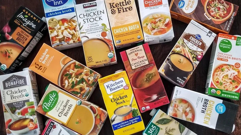A variety of chicken broth boxes on a wooden table top