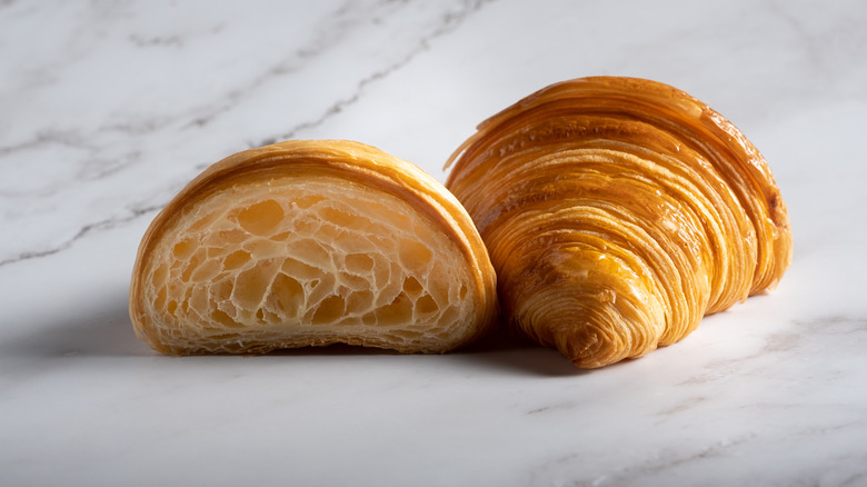 two halves of a croissant on marble table