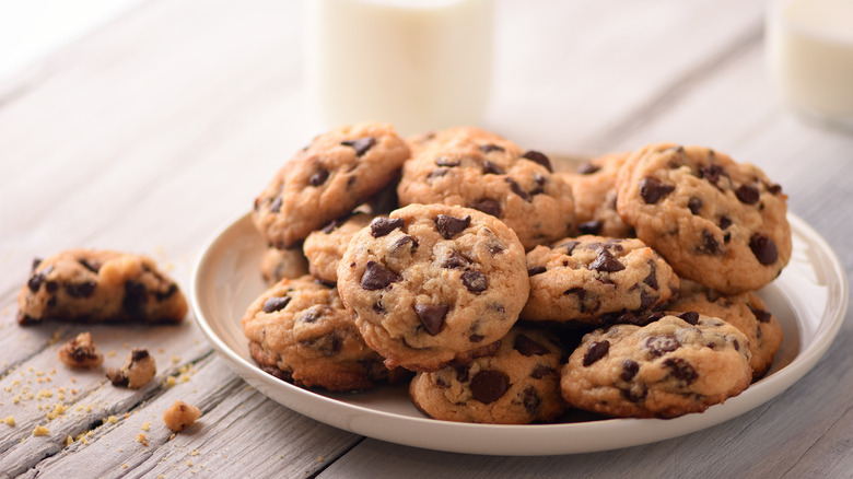 chocolate chip cookies on plate with milk