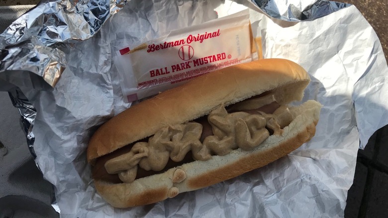 a hot dog with squeezed Bertman original Ball Park mustard packet