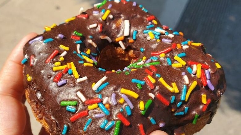 A sprinkles-topped chocolate frosted croissant donut from Bob's