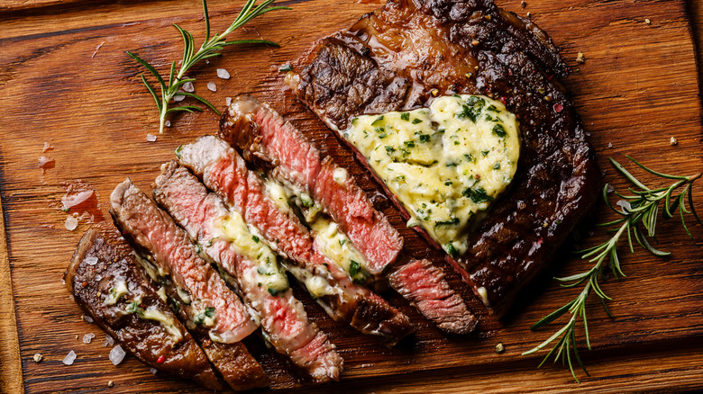 close up of a sliced steak with yellow sauce atop