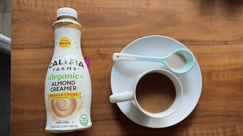 a container of Califia Farms Organic Banana Creme Creamer and a cup of coffee with a spoon
