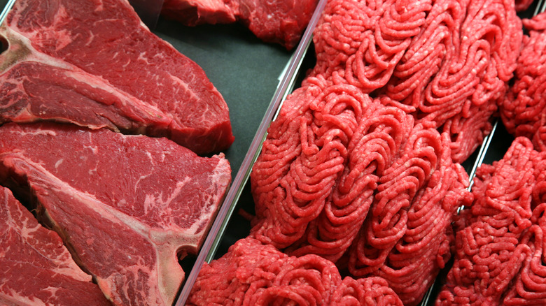 Steak and ground beef sit next to each other in a case.