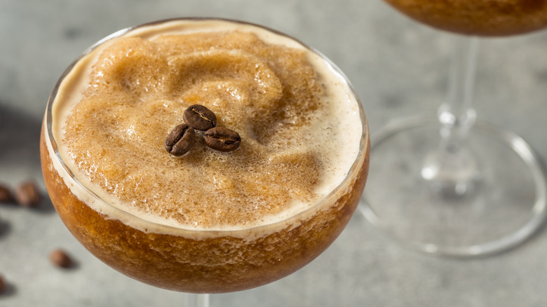 an overhead view of a slushy coffee drink in a coupe glass topped with coffee beans