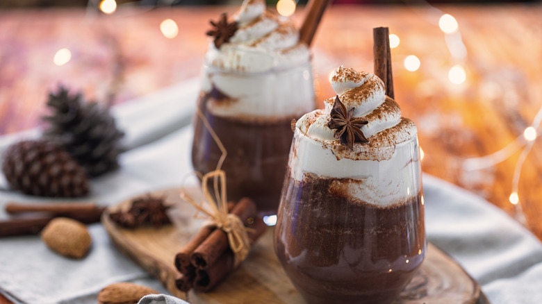 Mugs of hot chocolate with cloves and cinnamon