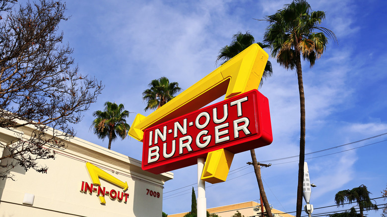 In-N-Out sign in front of palm trees and blue sky