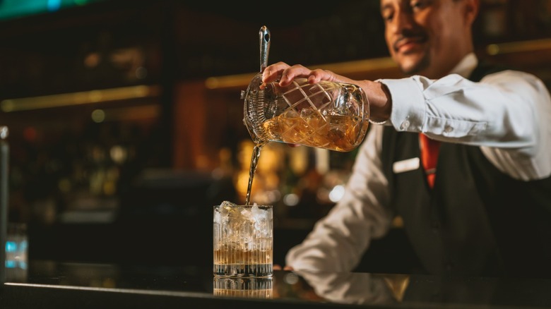a bartender at Capital Grille pouring a cocktail into a glass