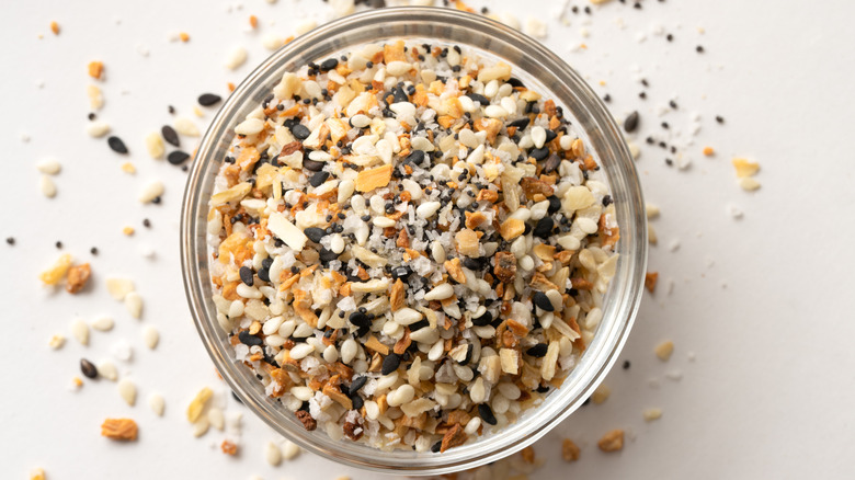A glass bowl of everything bagel seasoning viewed from above featuring sesame seeds, poppy seeds, dehydrated onion and salt