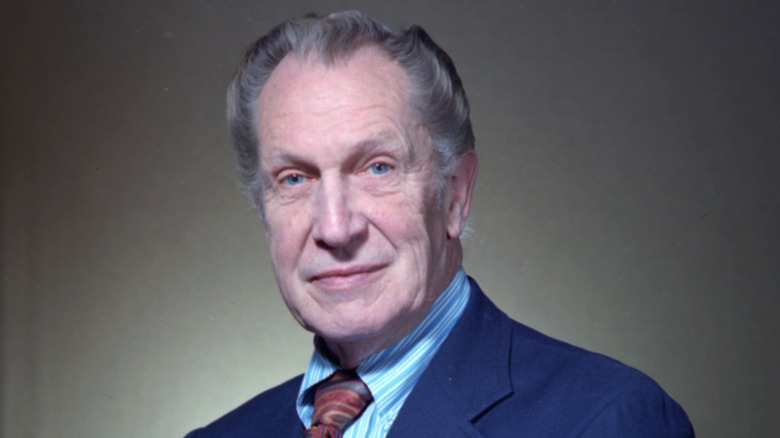 Vincent Price wearing a blue suit jacket with a light blue shirt and a multicolored tie