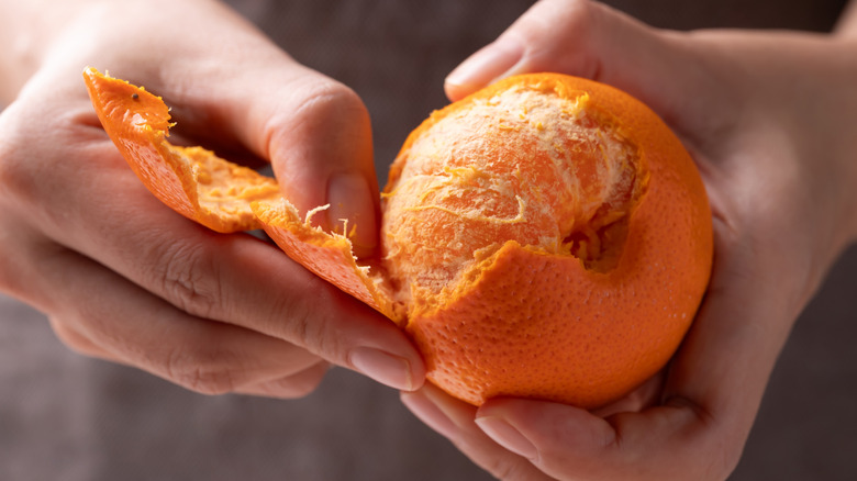 Person peeling an orange