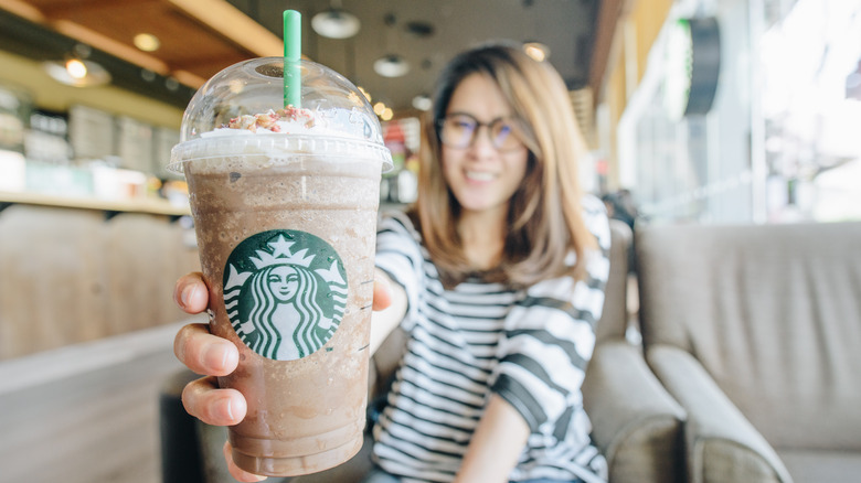 woman holding venti Starbucks drink