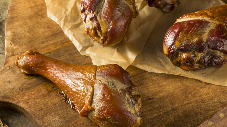 Smoked turkey legs on a wooden cutting board