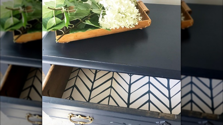 Dresser with tray of flowers, lined drawer open