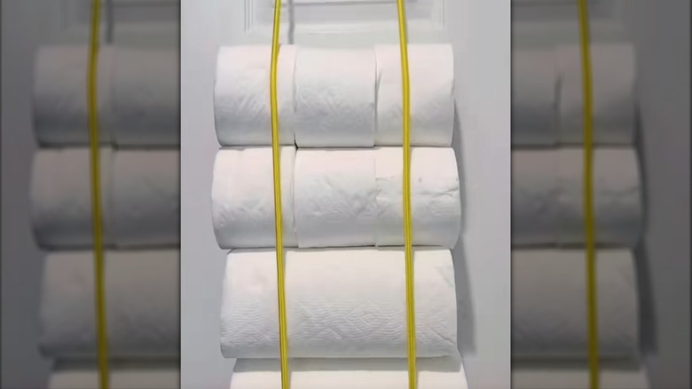 Paper towel rolls held to door with bungee cords