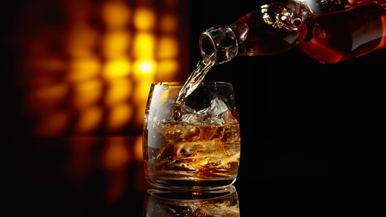 Batender pouring bourbon into a rocks glass