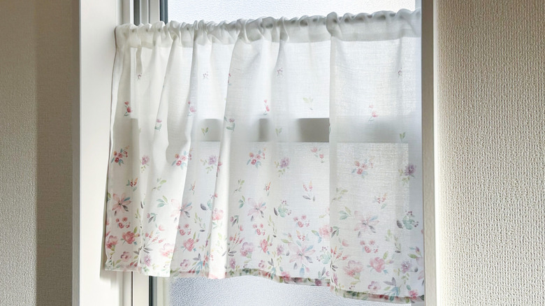 window with cafe curtain blowing in breeze