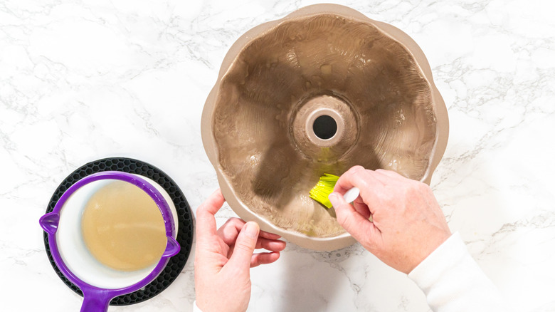 Person greasing a Bundt cake pan