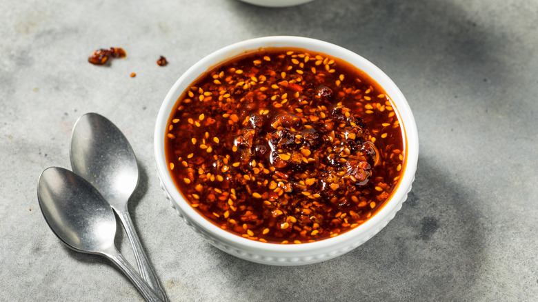 Chile crisp in a bowl with spoons nearby