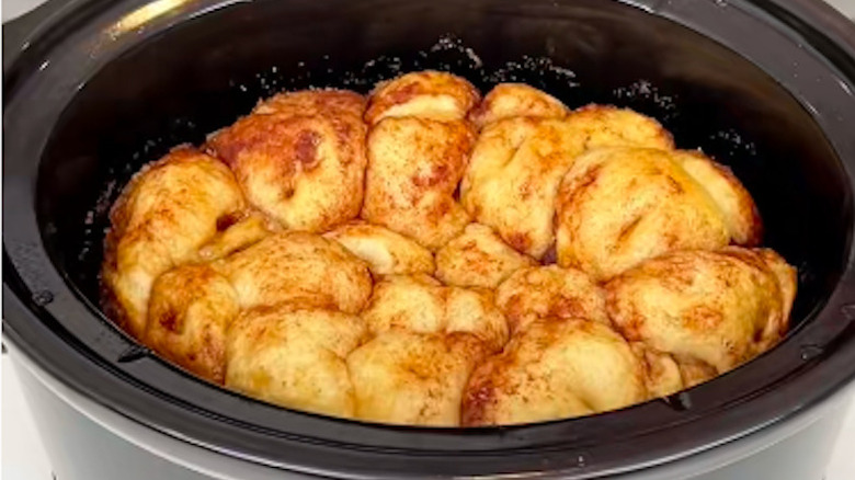 Slow cooker cinnamon rolls puffed up inside the bowl
