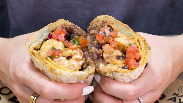 Someone holding a burrito from Baja Fresh Mexican Grill