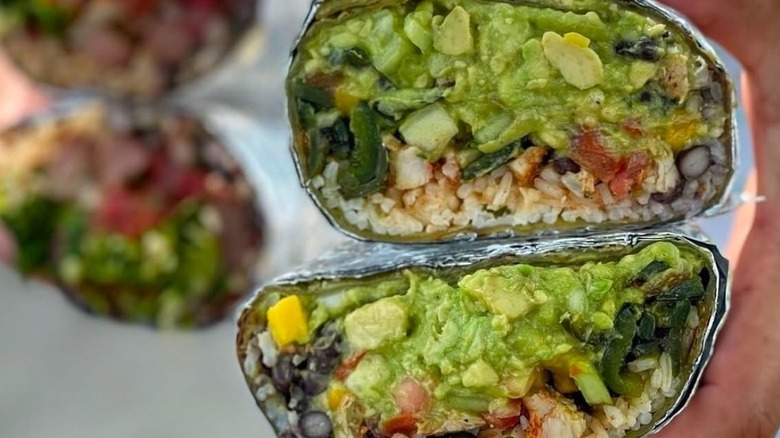Someone holding a burrito from Cabo Bob's