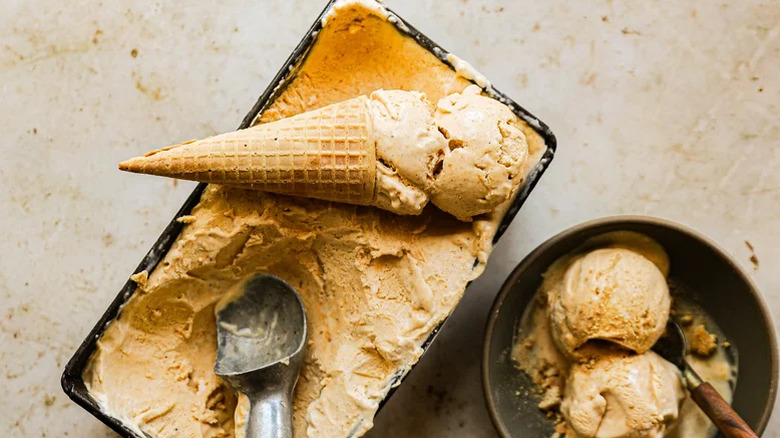 Butterscotch being poured over a bowl of pumpkin pie ice cream