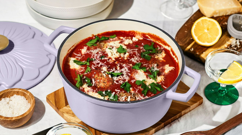 A chicken and tomato dish served in a lavender Beautiful Enameled Cast Iron Round Dutch Oven