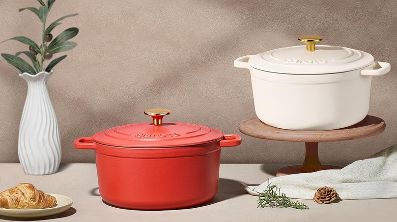 Red and white CAROTE Enameled Cast Iron Dutch Ovens displayed on a table