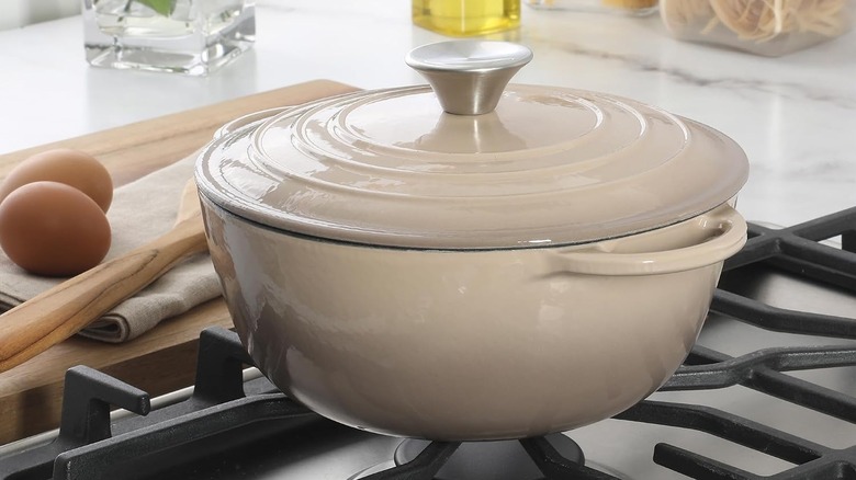 A mushroom-colored Gibson Home Addlestone Enameled Cast Iron Dutch Oven on a stovetop