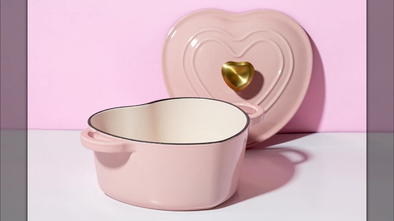 A pink Paris Hilton Enameled Cast Iron Heart-Shaped Dutch Oven on a table