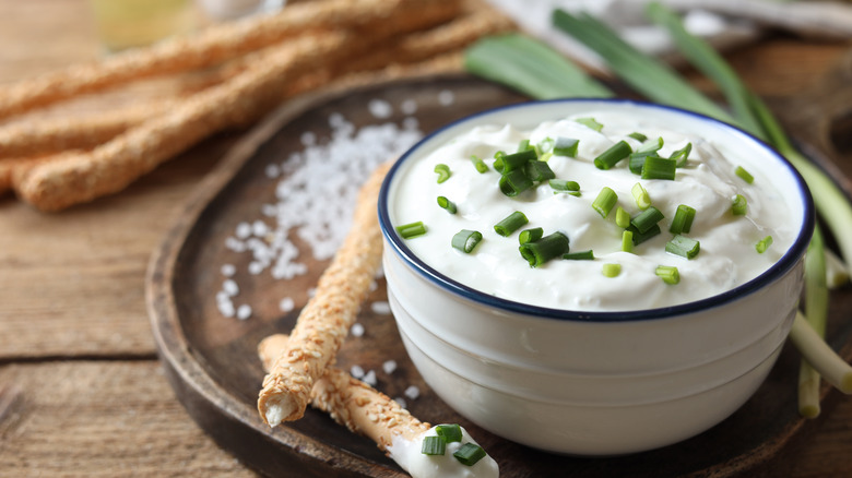 bowl of onion dip with breadsticks on the side
