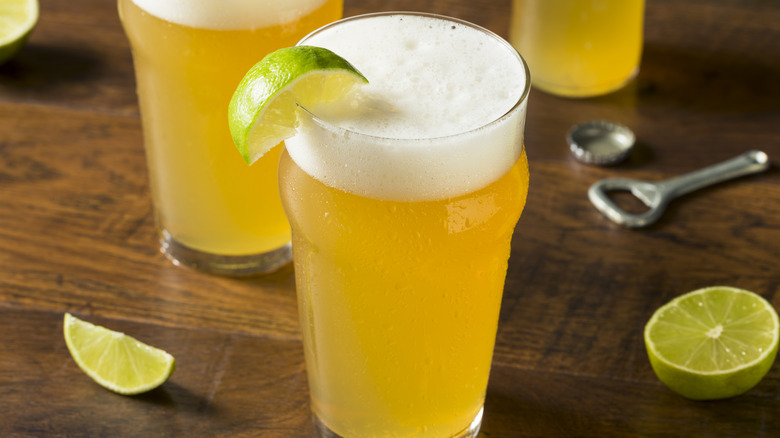 Pint glasses of lager with lime wedges