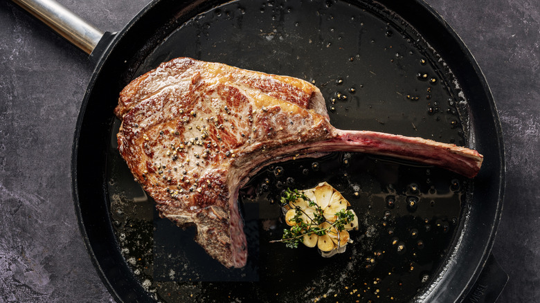 A ribeye steak in a searing pan.
