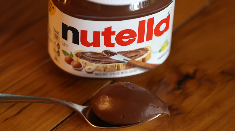 Jar of Nutella with a spoonful of it sitting in front