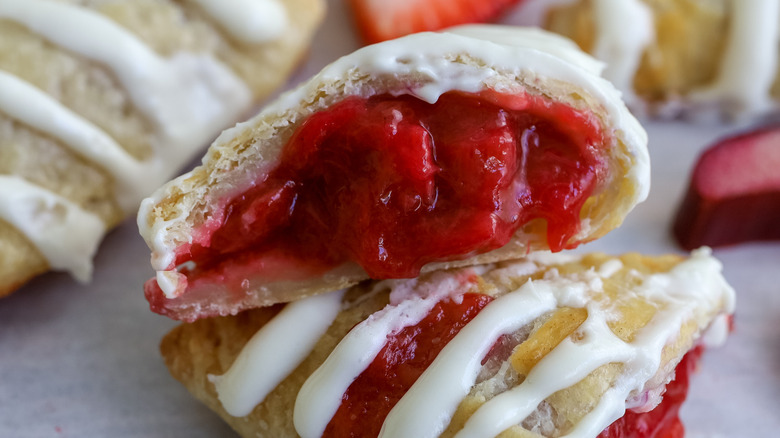 A cut strawberry rhubarb turnover with the filling oozing out