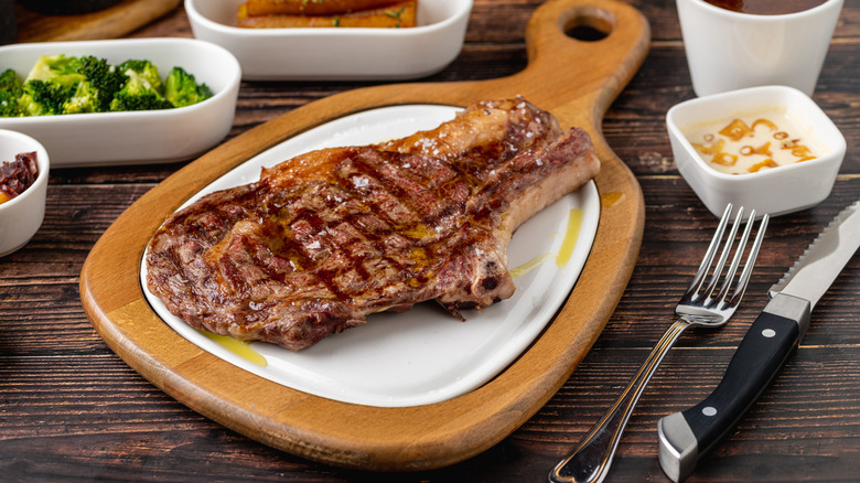 Grilled ribeye stak served on a wooden cutting board