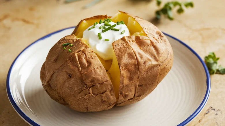 Baked potatoes on a plate with sour cream