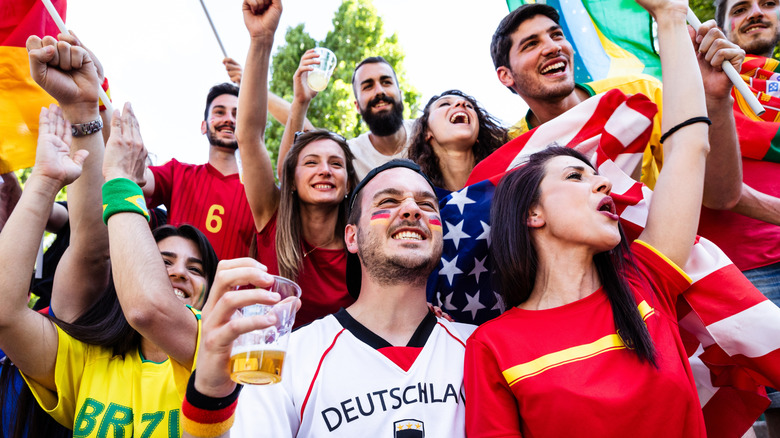 A group of soccer fans from around the world cheering together